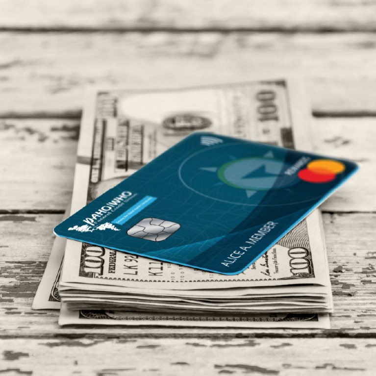 Picture of a PAHO WHO FCU World Rewards credit card on cash