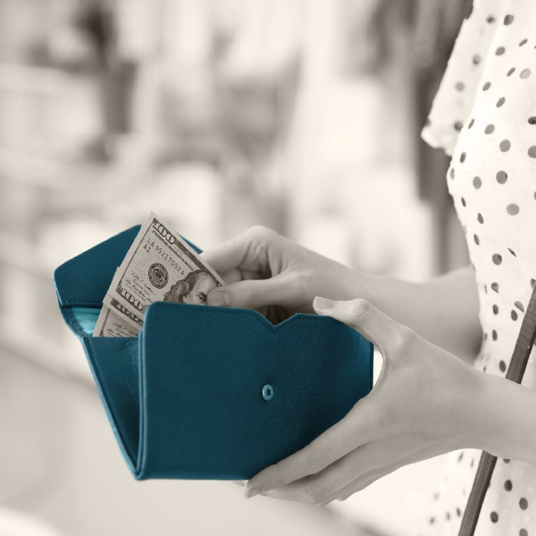 person pulling money from a teal wallet