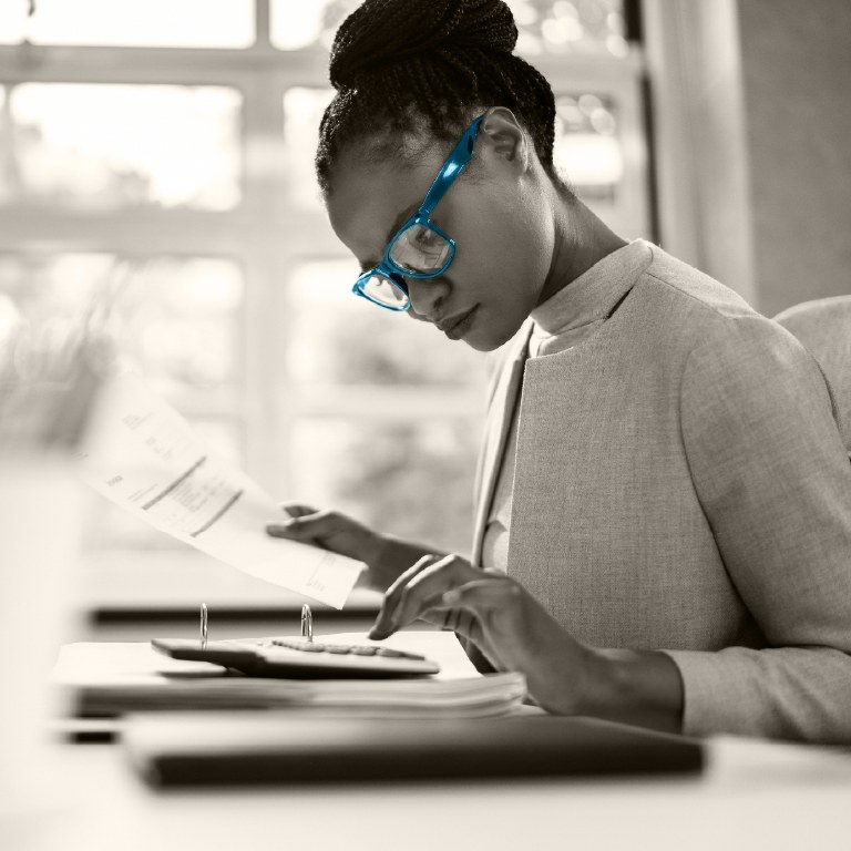 woman with blue glasses working on laptop