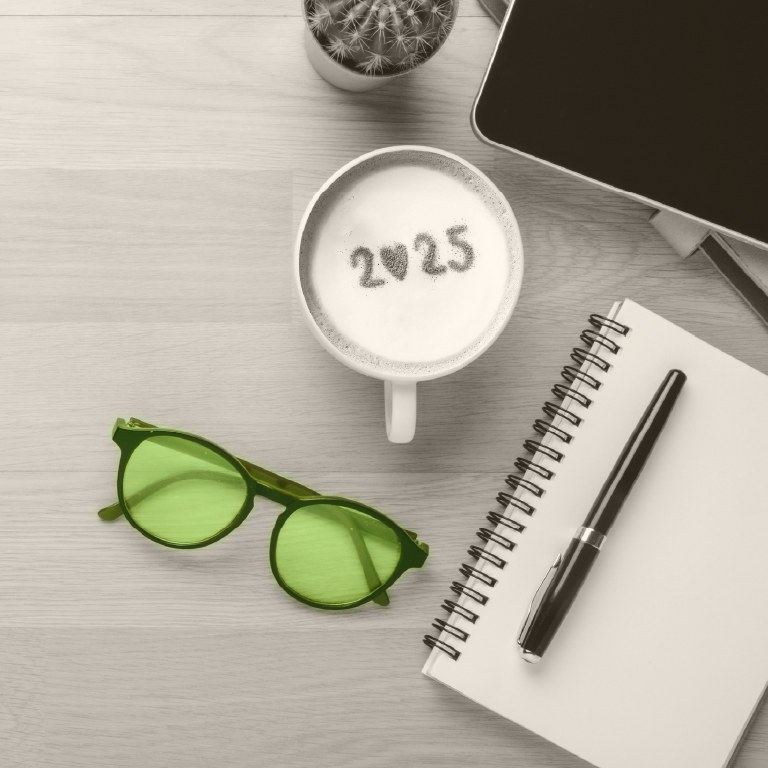 table with coffee cup with 2025 in foam lapton on a table