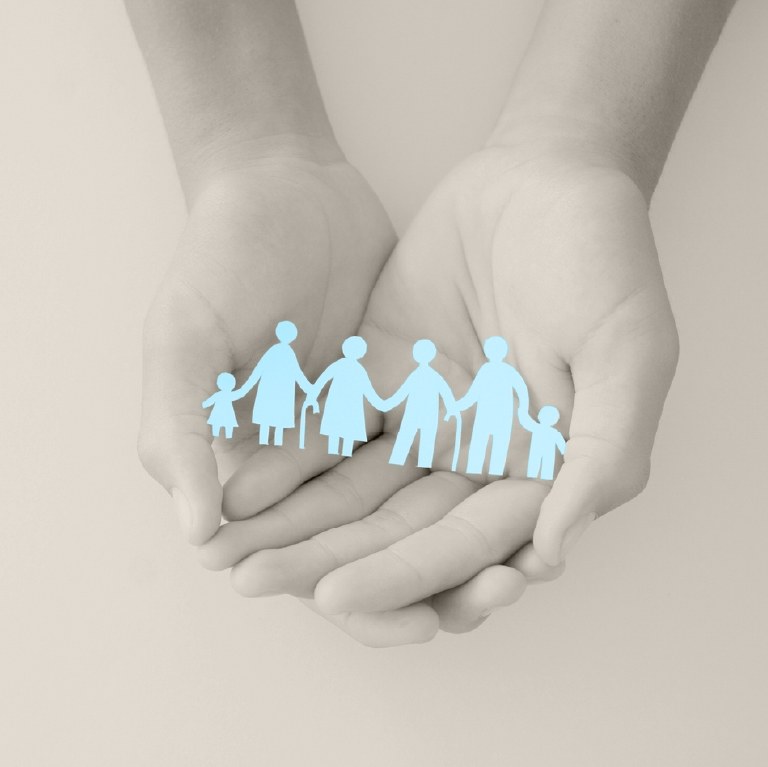 hands with paper coutout of family in blue