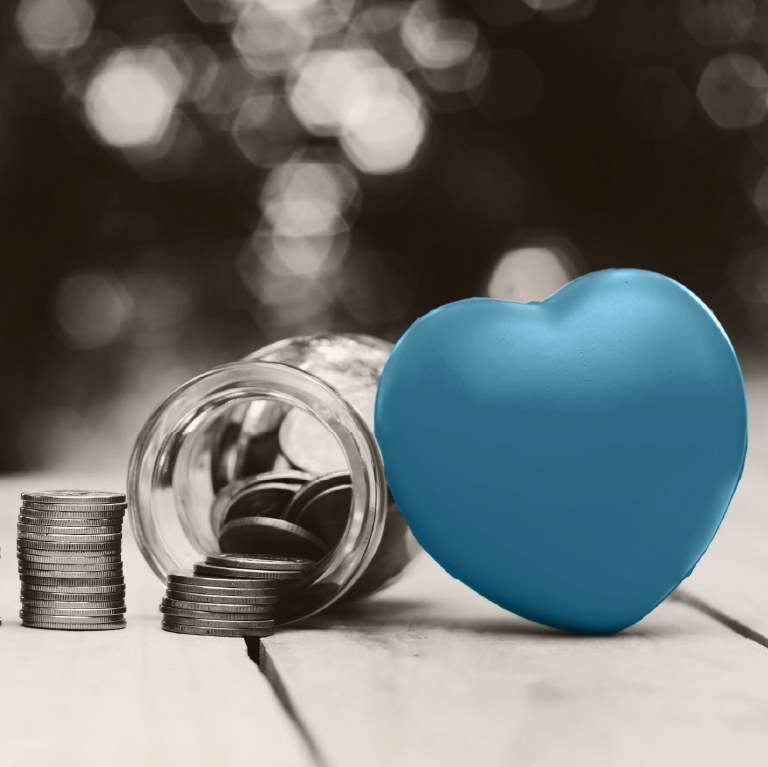 teal heart next to an overturned jar of coins