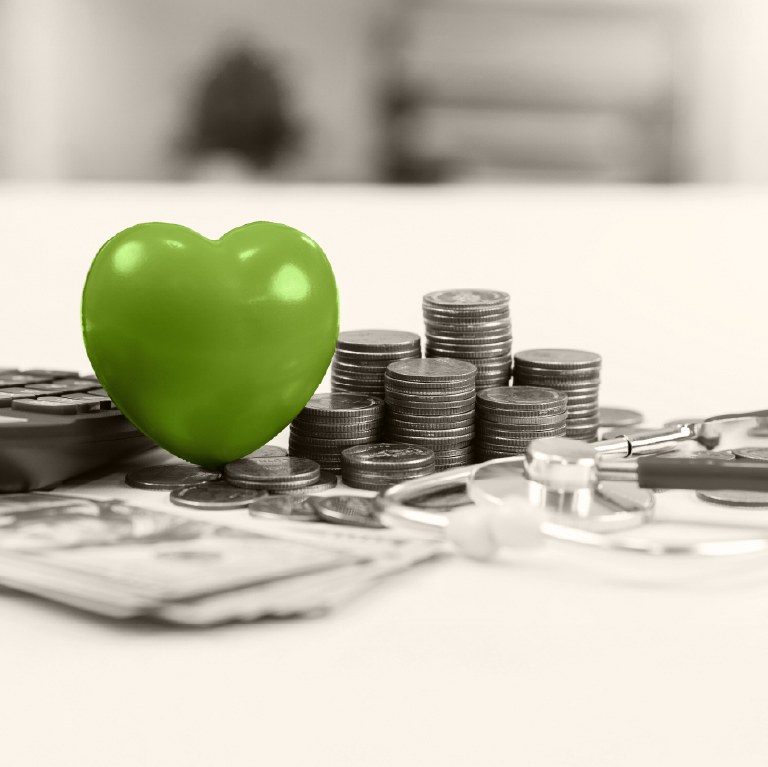 green heart stethescope over a calculator