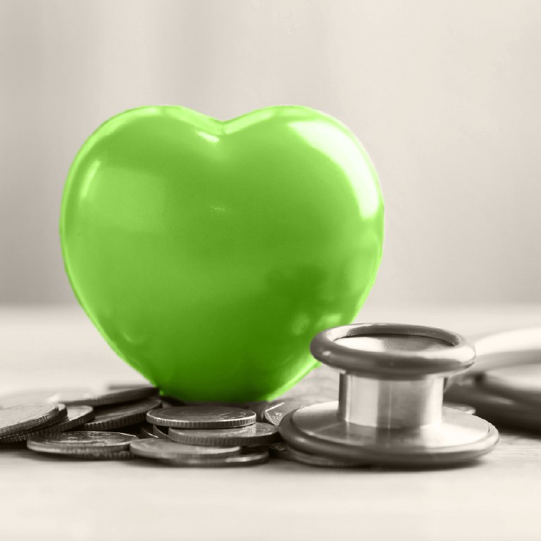 green heart over money and stethescope