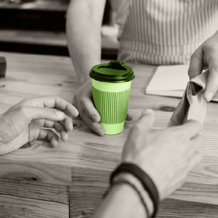 someone buying a cup of coffee at the counter