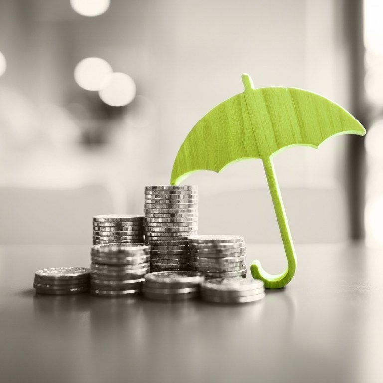 green umbrella with coins on a desk