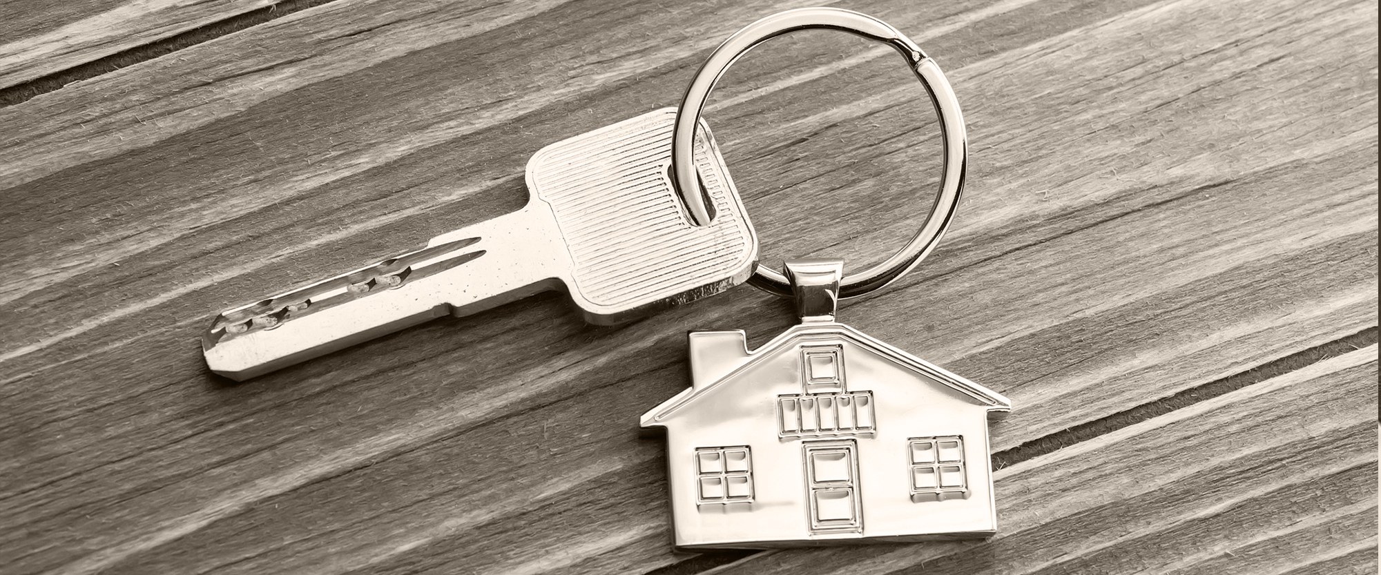 a house keychain with a key attached thrown on the table