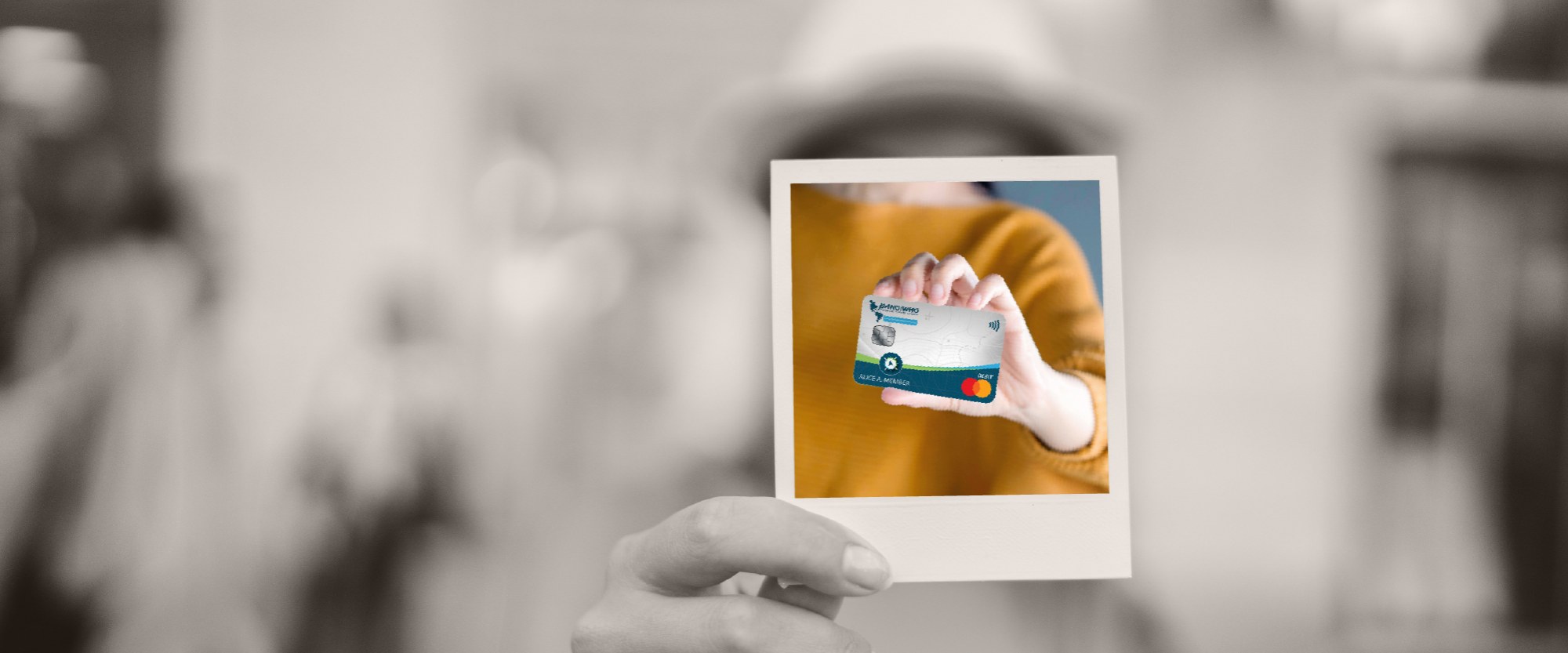hand holding a polaroid with image of credit card