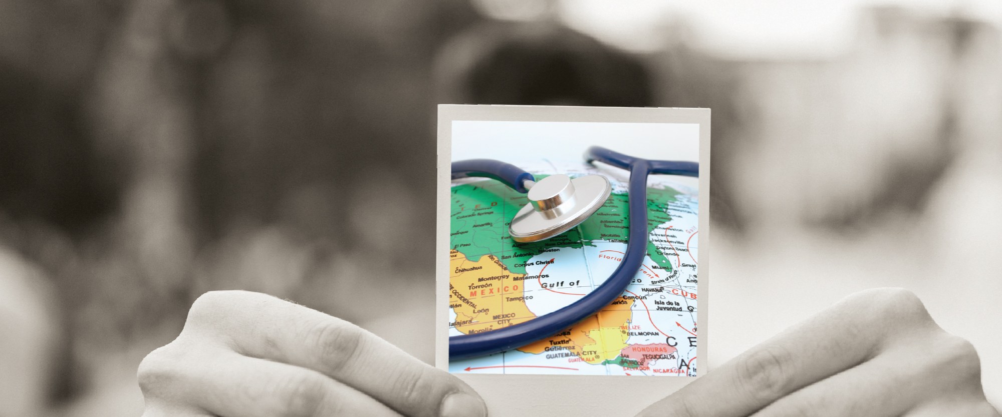 hand holding polaroid of a map with stethoscope in hand