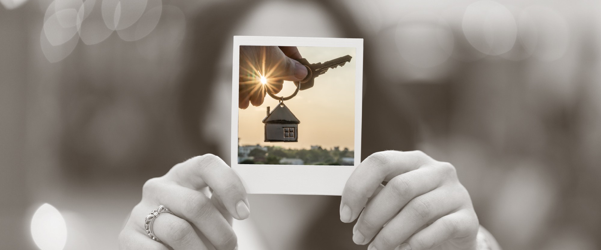 hands holding a picture of house keys