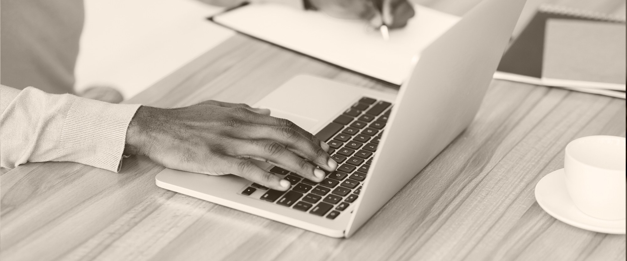 woman's hand typing on a laptop