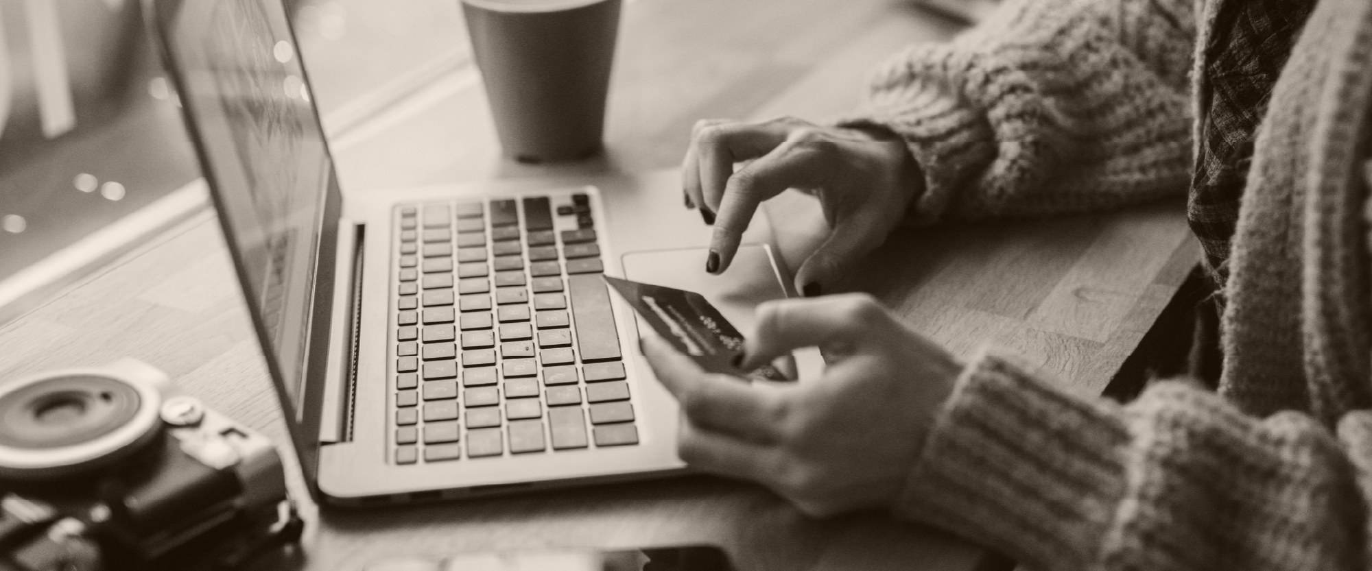 hand entering info on a laptop on desk