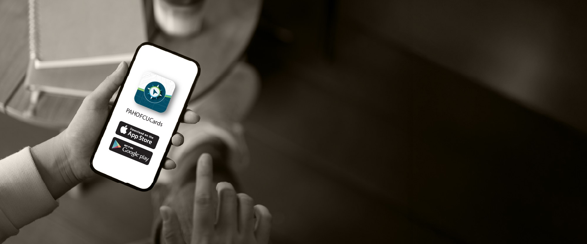 person holding their smartphone with rewards card next to it