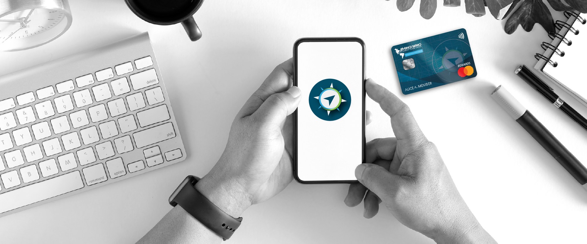 person holding their smartphone with rewards card next to it