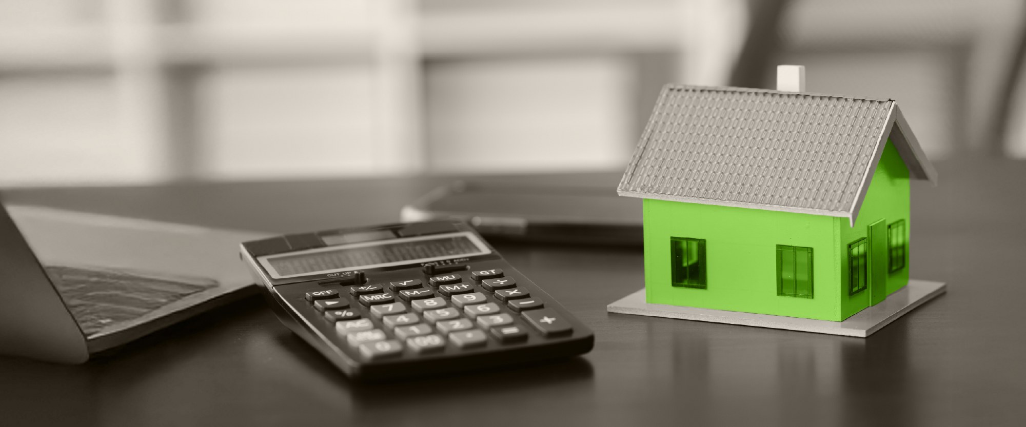 green house of wood next to a calculator on a table