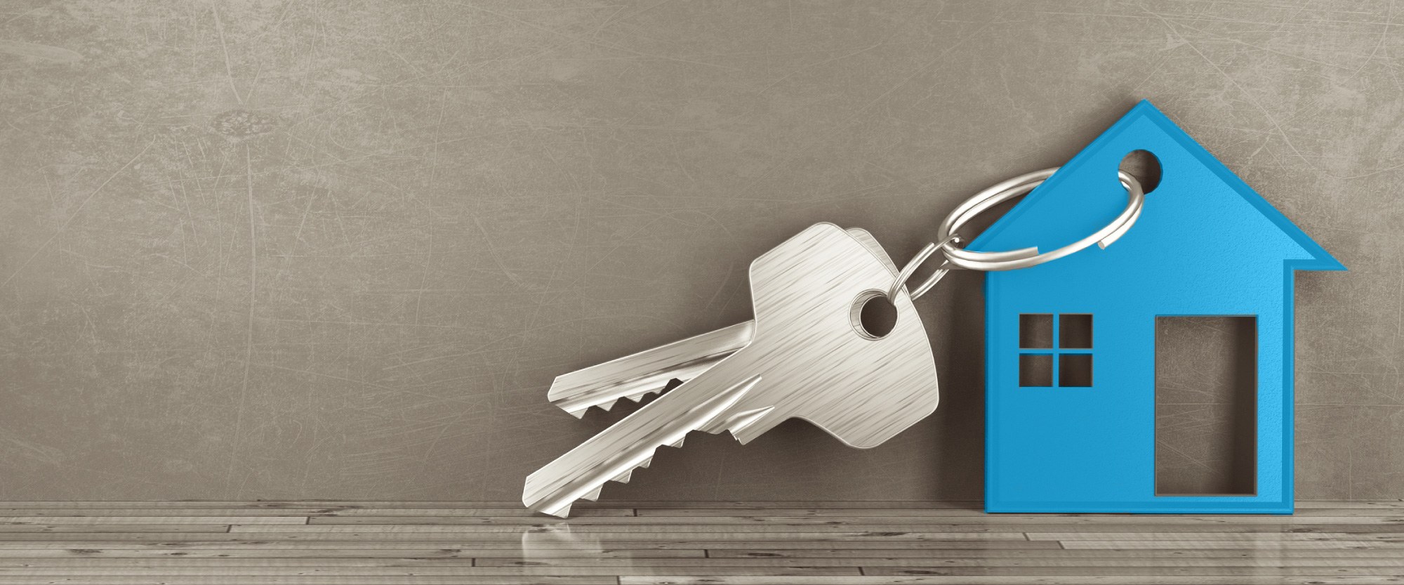 a keychaing with a blue house propped up on a wood floor