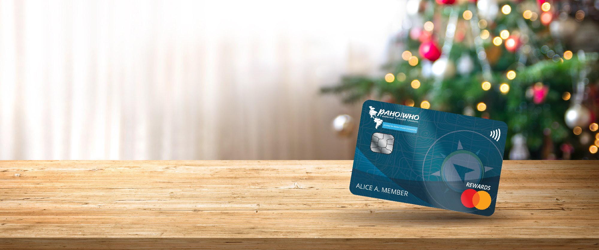 PAHOFCU world rewards card with holiday lights and a christmas tree background