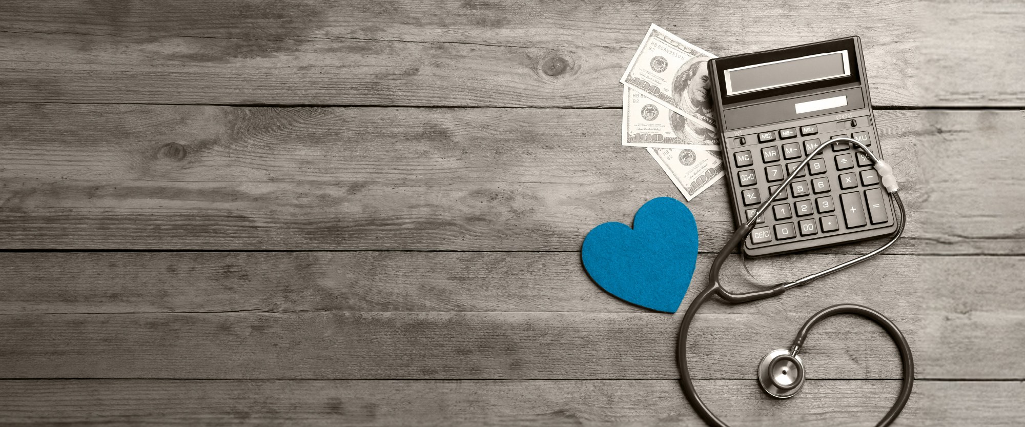 teal heart with stethescope next to calculator