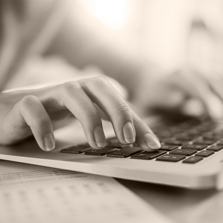 Person typing on laptop keyboard