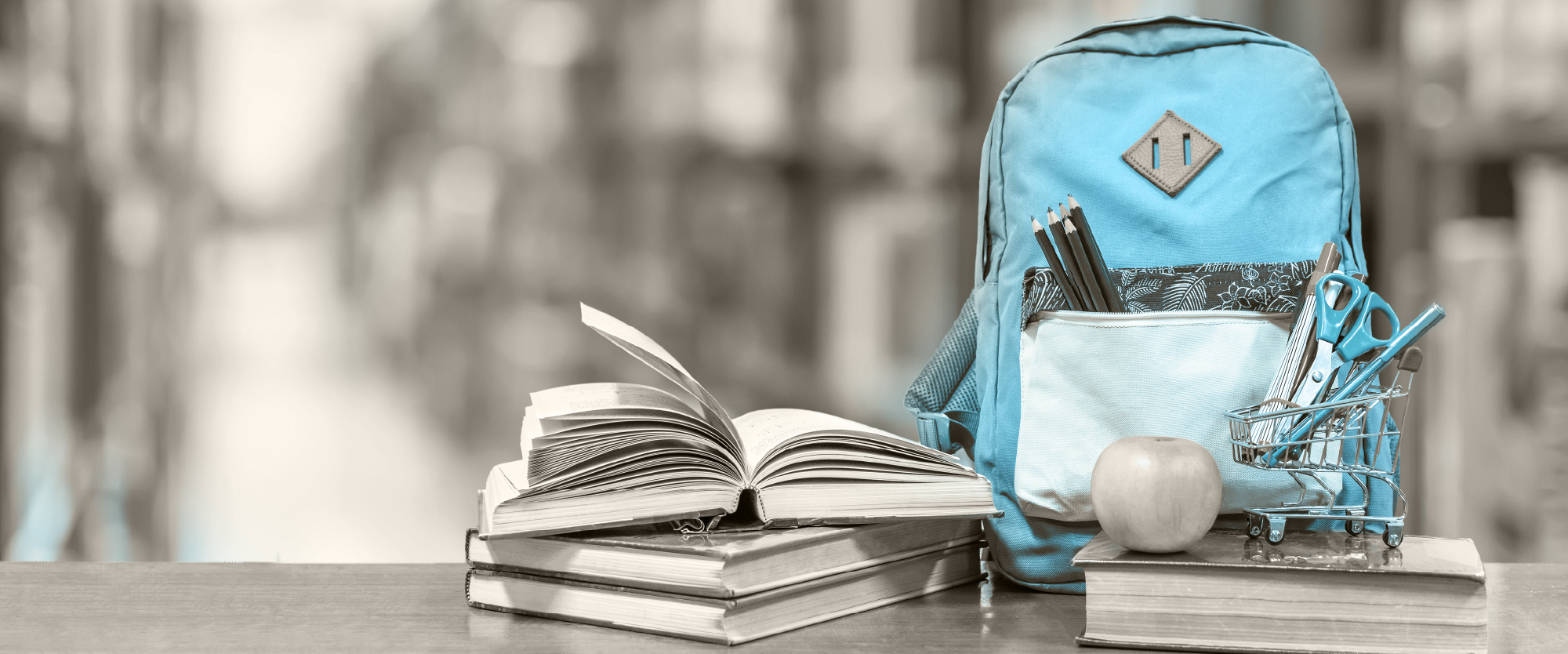 Bright blue backpack with back to school supplies next to it