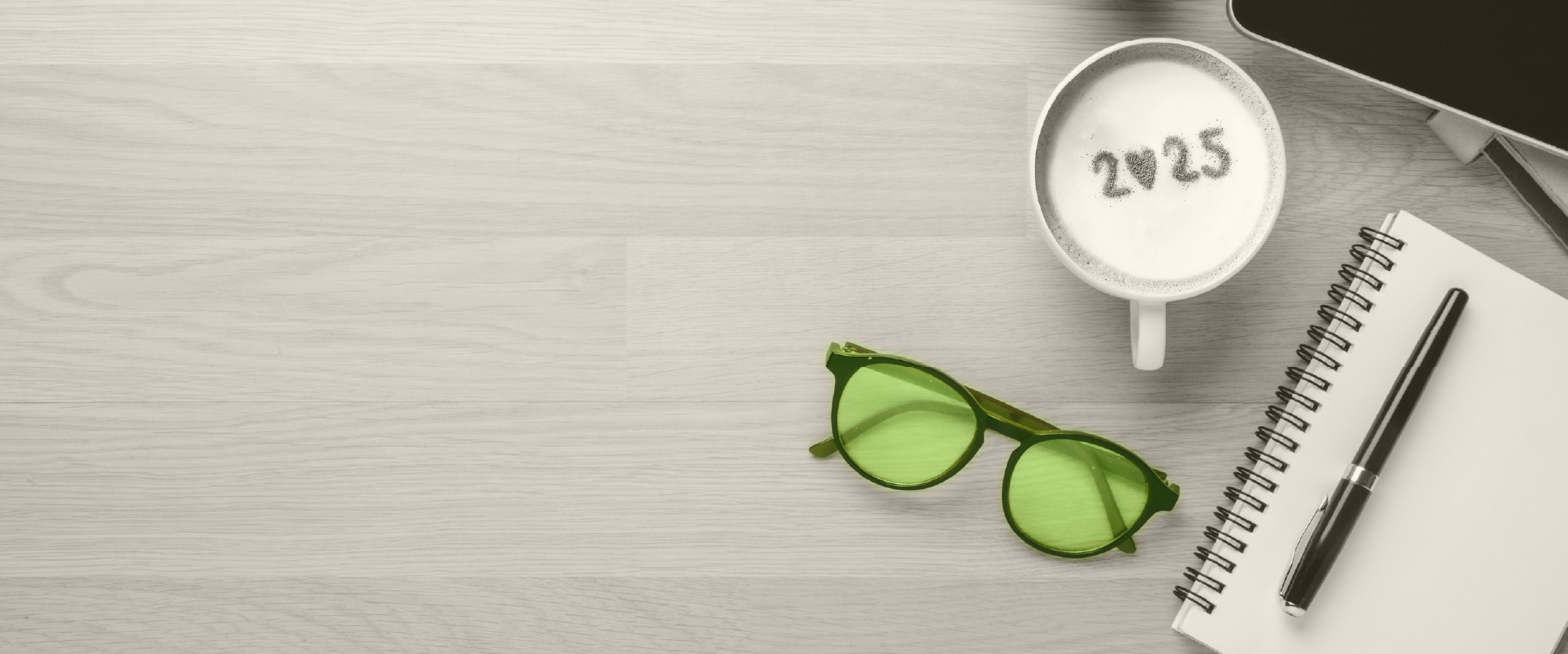 table with coffee cup with 2025 in foam lapton on a table
