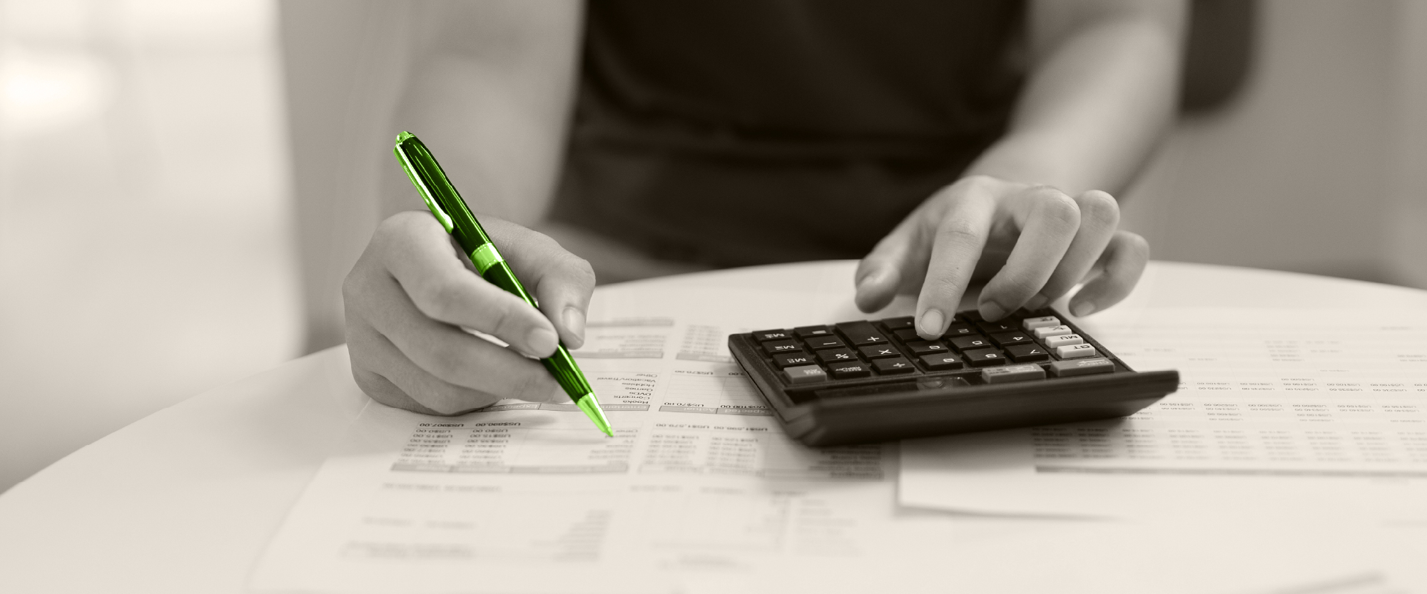 hand writing and checking budget with a calculator